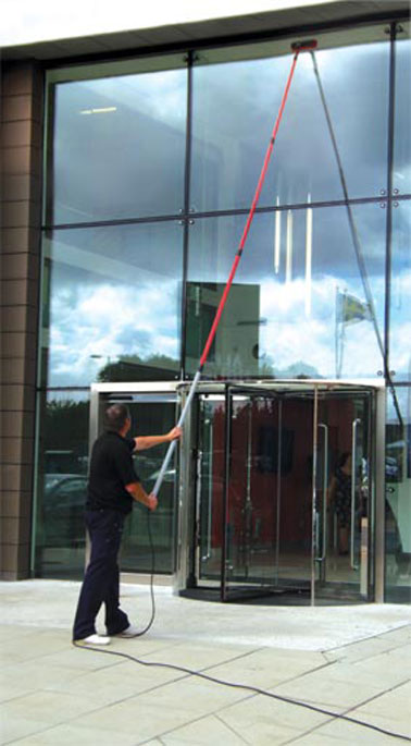 Image of man cleaning windows using waterfed pole sytem on an office in the Helensburgh & Dumbarton Area